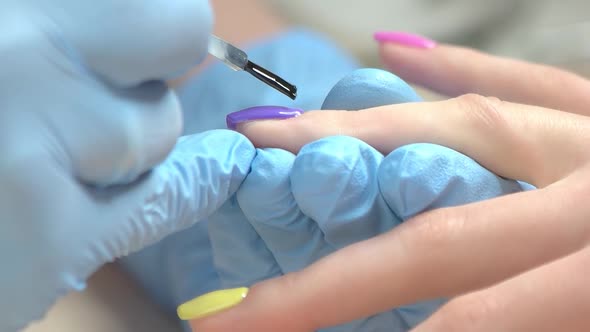 Manicurist Covers Nail with Fixer Close Up.