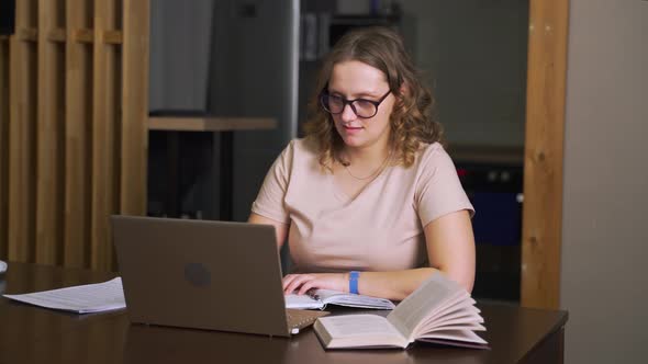 Woman with Glasses is Sitting at Desk and Working at Home Communicating with Colleagues and Friends