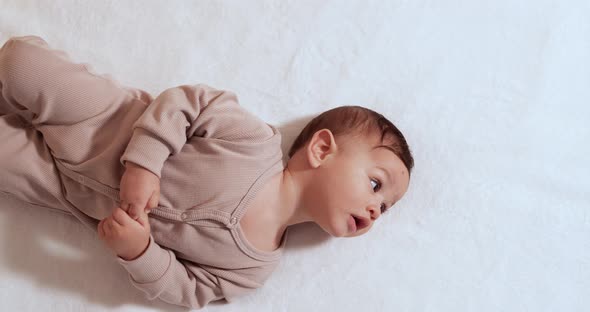 Happy Baby Boy Lying Roll Over in Bed