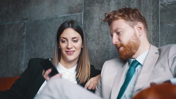 Business people using smartphone in a lobby of a hotel