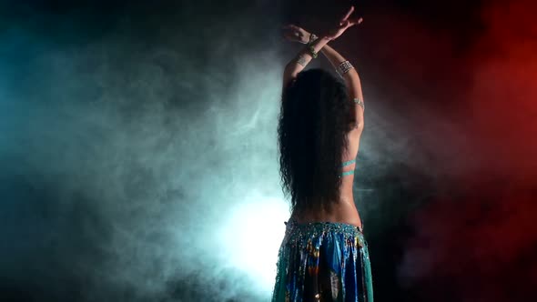 Torso of a Beautiful Young Girl Belly Dancer on a Black, Smoke, Back Light, Cam Moves Down