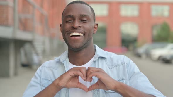 Outdoor Portrait of African Man Showing Heart Shape By Hands