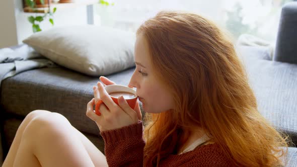 Woman having coffee in living room 4k