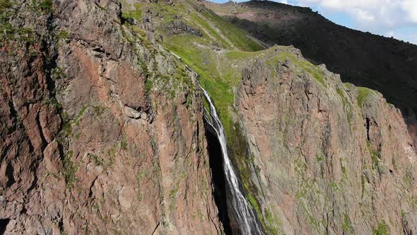 Amazing Waterfall Between Steep and High Rocky Mountains Aerial View