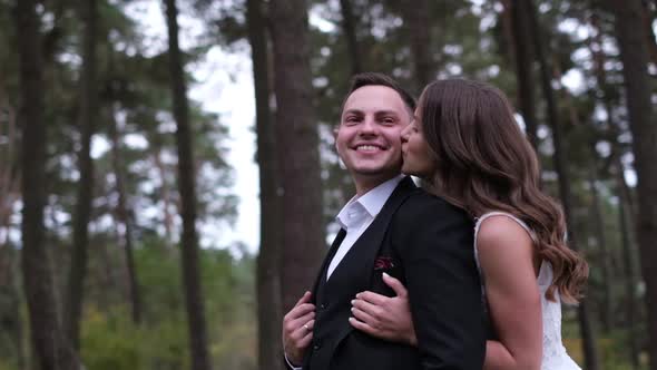 Young Couple on Their Wedding Day Walking in a Pine Park