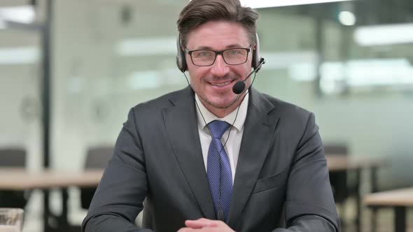 Middle Aged Businessman with Headset Smiling at Camera