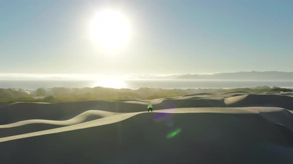 Person in Virtual Reality Headset Plays Virtual Reality in Sand Desert at Sunset