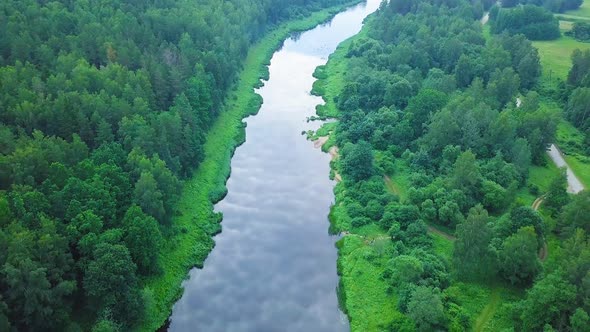 Aerial birdseye view of a Venta river (Latvia) on a sunny summer day, lush green trees and meadows,