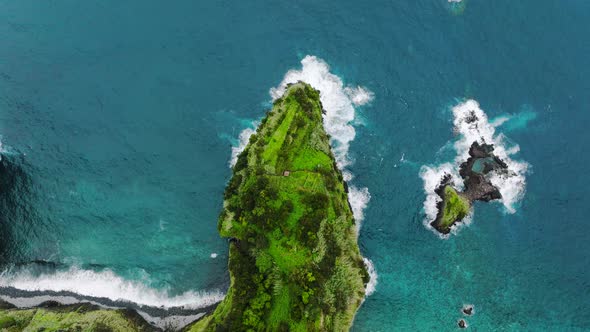 Dramatic headland jutting into clear Atlantic on Madeira coastline; aerial