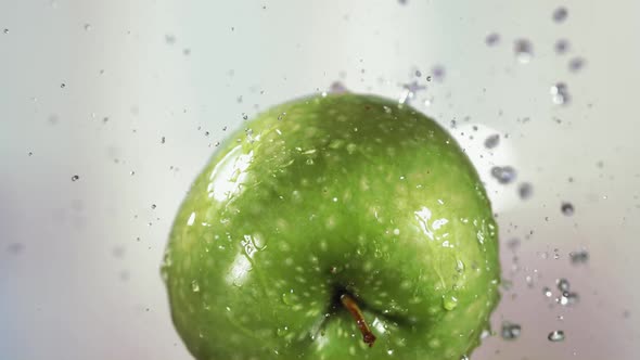 Flying of Green Apple in White Kitchen Background in Slow Motion