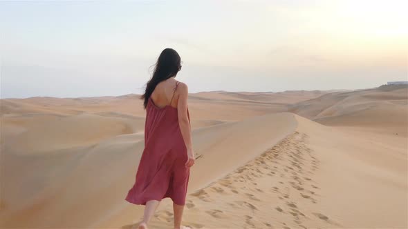 Girl Among Dunes in Rub al-Khali Desert in United Arab Emirates