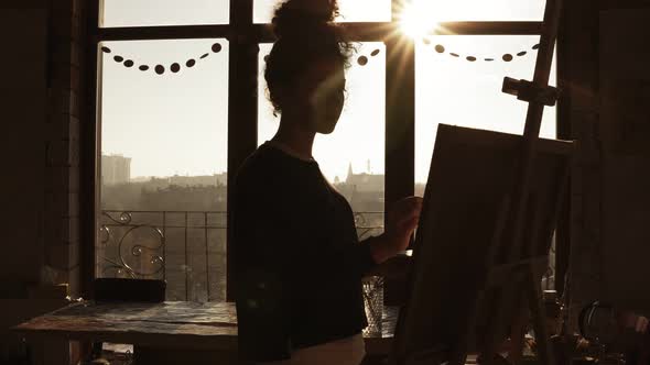 Cute Female Artist in Her 20's is Drawing Picture on Easel