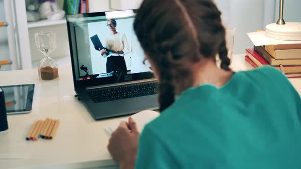 Teenage Girl Communicating with Her Teacher Using Her Laptop, Online Lesson Concept.