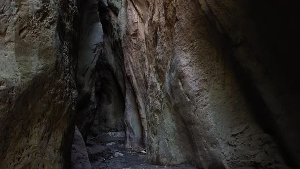 Camera move at the narrow canyon of a mountain gorge, illuminated by the sun