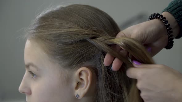 Hairdresser Makes Pigtails To a Girl