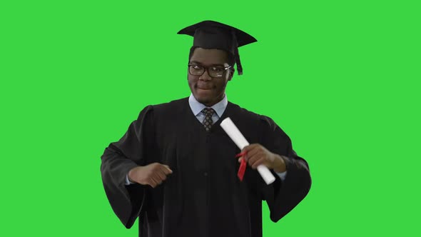 Excited African American Male Student in Graduation Robe Dancing with His Diploma Moving Towards