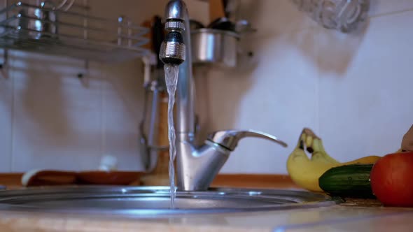 Female Hands Washing a Cucumber Apple Bananas with Running Water From the Tap