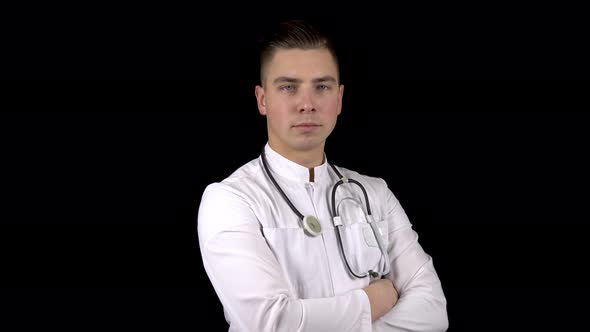 A Young Male Doctor Turns His Head Looking at the Camera and Smiling