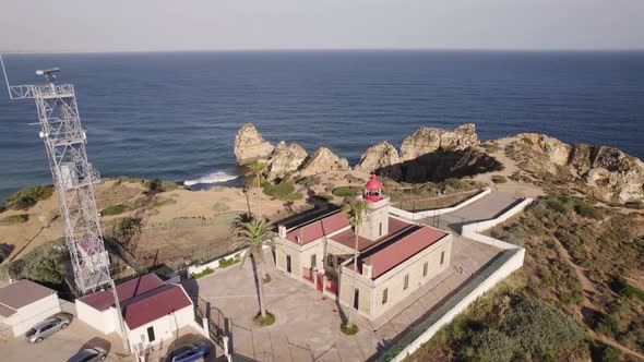 Aerial of the lighthouse of Lagos, Portugal overlooking the cliffs of the sea
