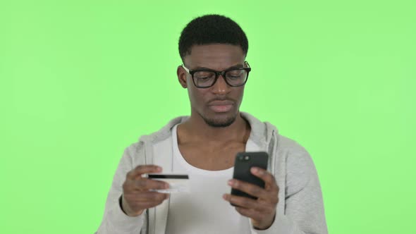 Online Shopping Failure on Smartphone for African Man on Green Background