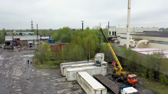 Aerial Footage of a Crane Unloading a Container From a Truck
