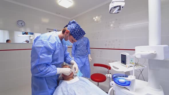 Dentist is treating a patient in a modern dental office. 