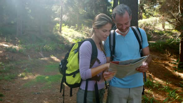 Hiker couple interacting while looking at map