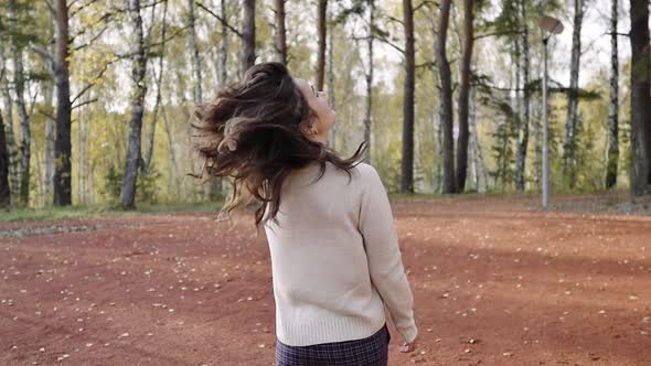 A Young Woman Walks in the Autumn Park. Brunette Woman Jumping and Dancing in the Forest. Freedom