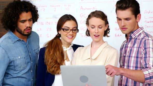 Business executives discussing over laptop in meeting