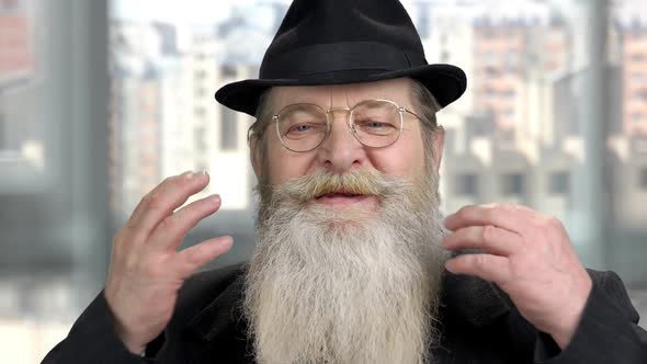 Old Senior Man Touching and Smoothing His Long Gray Beard and Moustache