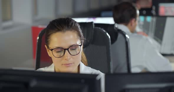 Female Engineer Working on Computer with Two Monitors