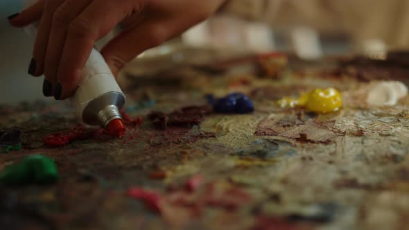 Unrecognizable Woman Squeezing Red Paint Inside