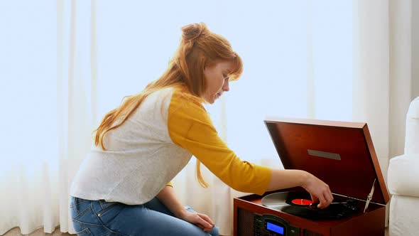 Beautiful woman listening music on turntable 4k