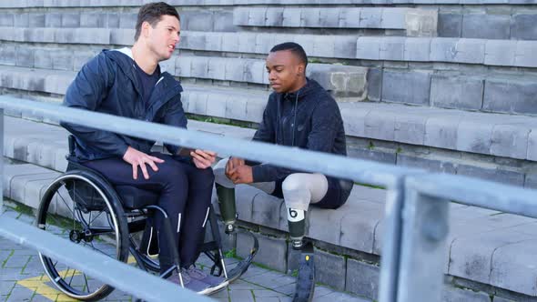 Two disabled athletics discussing over digital tablet 4k