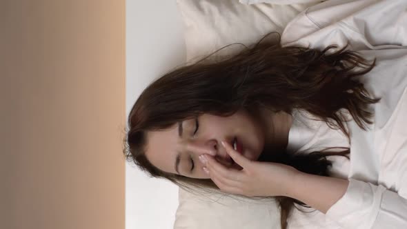 Vertical Shot Tired Beautiful Young Woman Yawning Putting on Sleep Mask and Falling Asleep