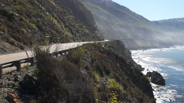 panning shot of a cycling riding the big sur coast of california