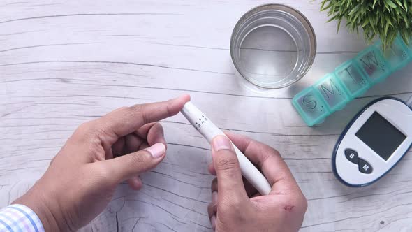 Young Man Doing Blood Sugar Test at Home