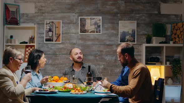 Man and Woman in Their Sixties Clinking a Glass of Red Wine