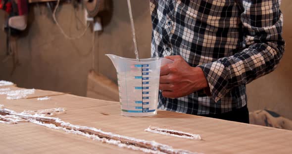 Close up of carpenter mixing epoxy resin with an electric mixer