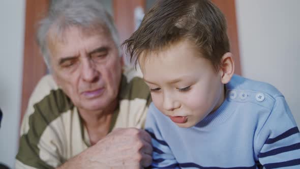 A caring grandfather is spending time with his grandchildren at home.