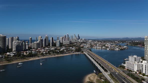 High view of a major bridge and roadway feeding into a city full of high-rise buildings and surround