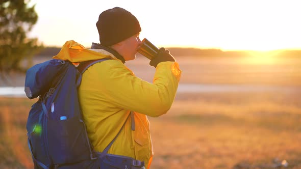 Hiker Young Tourist Enjoying Nature Drinking Hot Tea at Sunset