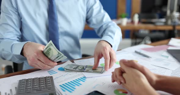 Businessman Counting Dollar Bill in Front of Woman in Office  Movie Slow Motion