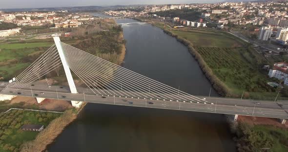 Aerial View Of Rainha Santa Isabel Bridge Crossing Mondego River In Coimbra, Portugal - drone pullba