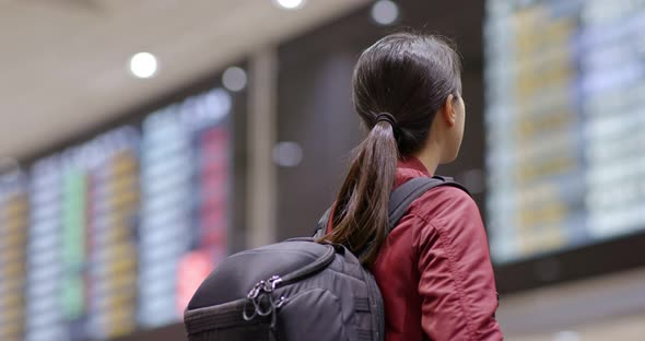 Woman use of mobile phone to check the flight number in the airport