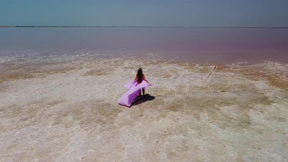 Woman in Flying Dress on Pink Salt Lake