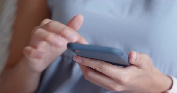 Woman use of cellphone and sit on sofa at home