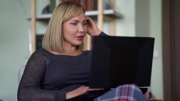 A Successful Woman at a Video Conference, Using a Laptop, Works at Home. Remote Meeting of Internet