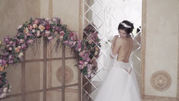 Slow Motion Wonderful Bride with Naked Back Near Flower Arch