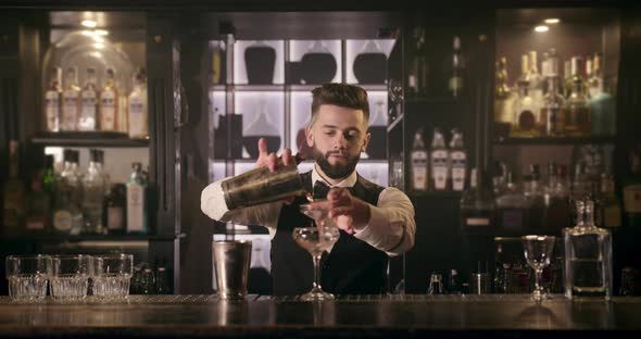 The Bartender Is Pouring the Alcohol From the Shaker Through a Cocktail Strainer Into the Glass. 